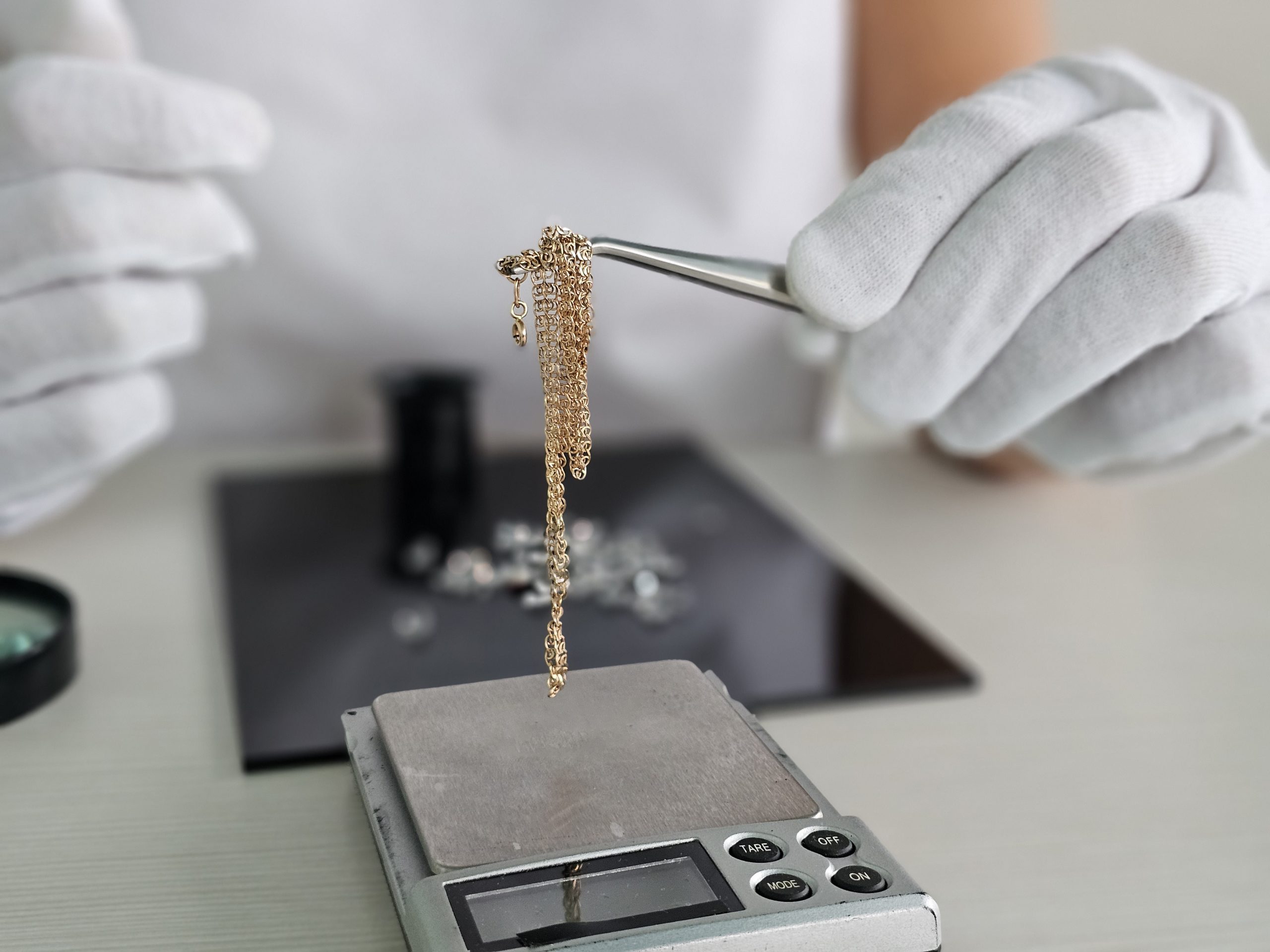 Jeweler weighs gold chain in pawn shop on scales concept