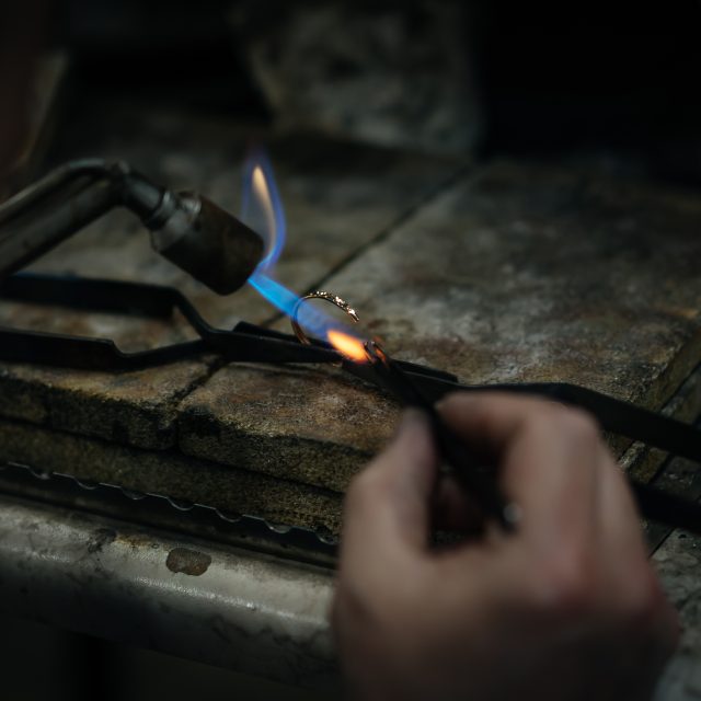 Craftsman is working by using a Gas spraying tool to make a ring
